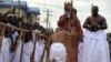 Un aide du palais s'agenouille devant le 40e monarque nouvellement couronné du royaume du Bénin Oba Ewuare II sur un pont en bois lors d'un rite pour marquer son couronnement à Benin City, dans le sud du Nigeria.