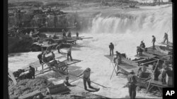 This historical photo provided by the Library of Congress shows Native Americans fishing for salmon at Celilo Falls, Oregon, on September 1941.