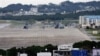 FILE - U.S military airplanes and helicopters sit on the airstrip at Futenma Marine Corps Air Station, surrounded by houses in Ginowan, Okinawa, Japan.
