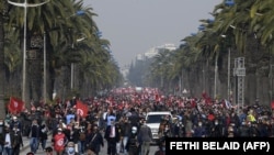 Des partisans du parti Ennahdha brandissent des drapeaux nationaux et du parti lors d'une manifestation de soutien au gouvernement tunisien le 27 février 2021 dans la capitale Tunis. 