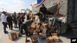 ARCHIVO - Palestinos saquean un camión con ayuda humanitaria cerca del cruce fronterizo de Rafah en la Franja de Gaza el jueves 2 de noviembre de 2023.