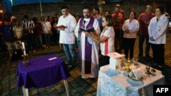 Seorang pendeta melangsungkan misa dekat sekolah umum Raul Brasil, setelah terjadi penembakan du Suzano, daerah metropolitan Sao Paulo, Brazil, 13 Maret 2019 (foto: Nelson Almedia/AFP)