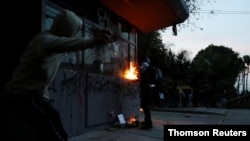 Manifestastes protestan frente a una comisaría después de que un hombre, que fue detenido por violar las reglas de distanciamiento social, y muriera por ser golpeado repetidamente con una pistola paralizante por agentes, según las autoridades, en Bogotá.