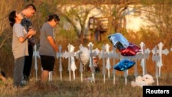 Miranda Hernandez (L) prays at sunset with father Kenneth and mother Irene at a row of crosses near the site of the shooting at the First Baptist Church of Sutherland, Texas, Nov. 6, 2017. 