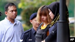 Tersangka terkait pembunuhan Kim Jong-nam, Doan Thi Huong (dua dari kanan) dikawal oleh polisi dari penjara di Sepang, Malaysia, 1 Maret 2017. (AP Photo/Daniel Chan). 