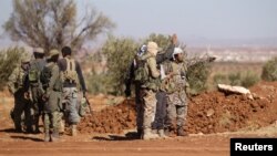 FILE - Rebel fighters gather during their advance toward the Islamic State-held city of al-Bab, northern Syria, Oct. 26, 2016. 
