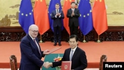 欧盟贸易专员霍根与中国商务部长钟山在北京人大会堂签署协议。（2019年11月6日）