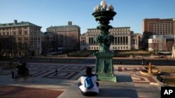 Seorang perempuan duduk di kampus Universitas Columbia, di New York, 9 Maret 2020. (Foto: AP)