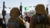 Hamas militants escort Israeli-Russian hostage Sasha Trupanov before handing him over to a Red Cross team in Khan Yunis, southern Gaza Strip, on Feb. 15, 2025, as part of the sixth hostage-prisoner exchange. 