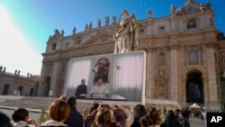 El Papa Francisco aparece en un monitor gigante instalado en la Plaza de San Pedro en el Vaticano, el 3 de diciembre de 2023, durante la tradicional oración del Ángelus del mediodía. 