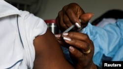 FILE - A man receives a vaccine against the COVID-19 at a mobile vaccination center in Abidjan, Ivory Coast, Sept. 23, 2021. 