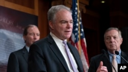 El senador Tim Kaine, demócrata por Virginia (centro) habla con los reporteros en una sesión en el Capitolio.