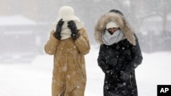 Warga Boston, Massachusetts, berjalan kaki di tengah badai salju pada musim dingin bulan Januari lalu.