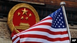 美国国旗与中国国徽。（资料照）