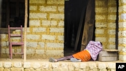 Seorang penderita ebola berbaring di lantai di luar rumahnya di pinggiran ibukota Freetown, Sierra Leone (21/10). Ebola telah menewaskan 4.900 orang lebih.