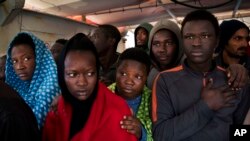 Les migrants à bord du bateau de sauvetage Golfo Azurro attendent d'être transférés aux autorités italiennes dans le port de Trapani, sur l'île italienne de Sicile, 8 avril 2017.