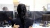 Una mujer migrante es abrazada por un niño dentro de una instalación de procesamiento temporal para migrantes, incluidos menores no acompañados, en Donna, Texas, EE. UU., 17 de marzo de 2021