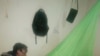 Une dame au Malawi en train d'installer une moustiquaire que seulement 55% des Malawiens utilisent pour se protéger contre le paludisme, selon les statistiques. (Lameck Masina/VOA)
