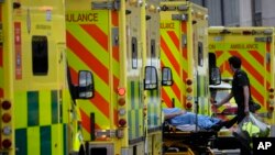 Seorang pasien didorong dengan troli dibawa masuk menuju Rumah Sakit Royal London di Whitechapel setelah sebelumnya tiba di rumah sakit tersebut dengan ambulan, pada 6 Januari 2022. (Foto: AP/Matt Dunham)