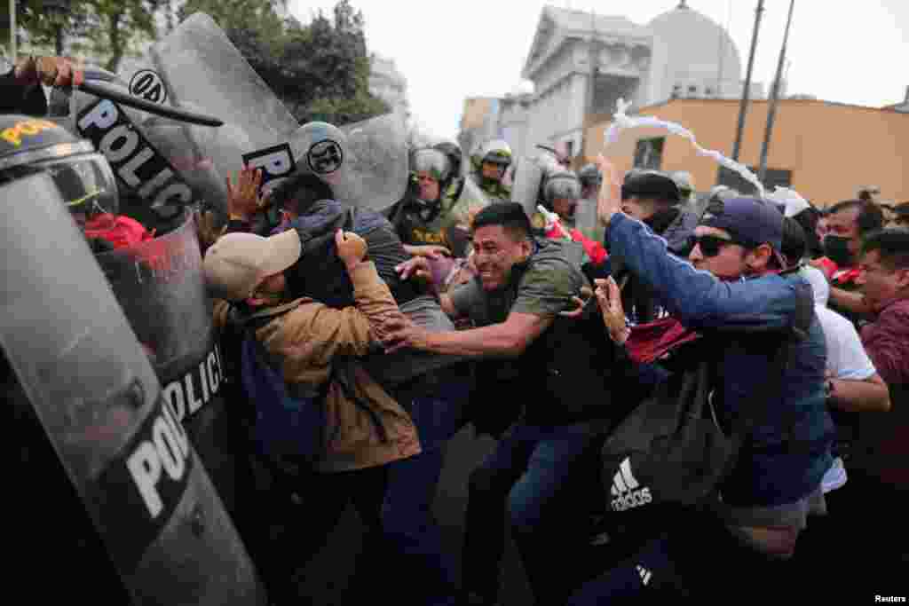 Manifestantes se enfrentan a la policía antidisturbios durante una protesta que exige elecciones presidenciales y el cierre del Congreso después de que Pedro Castillo fuera detenido en una prisión policial tras su destitución, en Lima, Perú, el 8 de diciembre de 2022. REUTERS/Sebastián Castañeda 