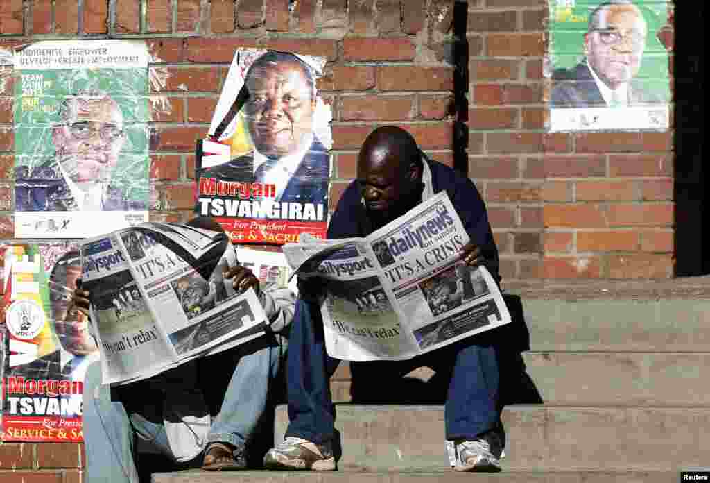 Locals read newspapers in Mbare township, outside Harare August 4, 2013. Africa's oldest president, Robert Mugabe, was declared winner of Zimbabwe's election that Saturday.