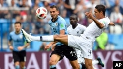 Raphael Varane, (derecha) de Francia, es desafiado por el uruguayo Cristhian Stuani durante el partido por cuartos de final entre Uruguay y Francia el viernes, 6 de julio de 2018, en Nizhny Novgorod, Rusia.