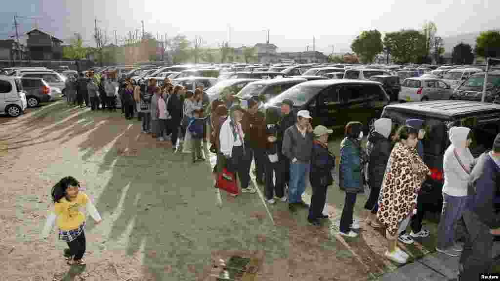 Des habitants font la queue pour obtenir de l'eau et de la nourriture dans une école élémentaire à Mashiki, préfecture de Kumamoto, Japon, 17 avril 2016. Photo prise par Kyodo. 