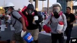 So-called "deactivators" carry large plastic bottles filled with a mixture of water, baking soda and vinegar, during clashes with police in Lima, Peru, Jan. 26, 2023.