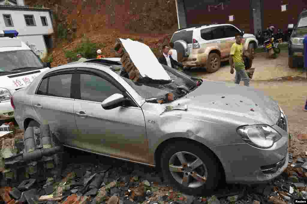 A car smashed by debris after an earthquake hit Longtoushan township, Ludian county, Yunnan province, Aug. 4, 2014. 