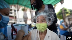 Una enfermera inmuniza a una mujer con una dosis de la vacuna Sputnik V en el barrio 23 de Enero en Caracas, Venezuela, el 9 de junio de 2021.