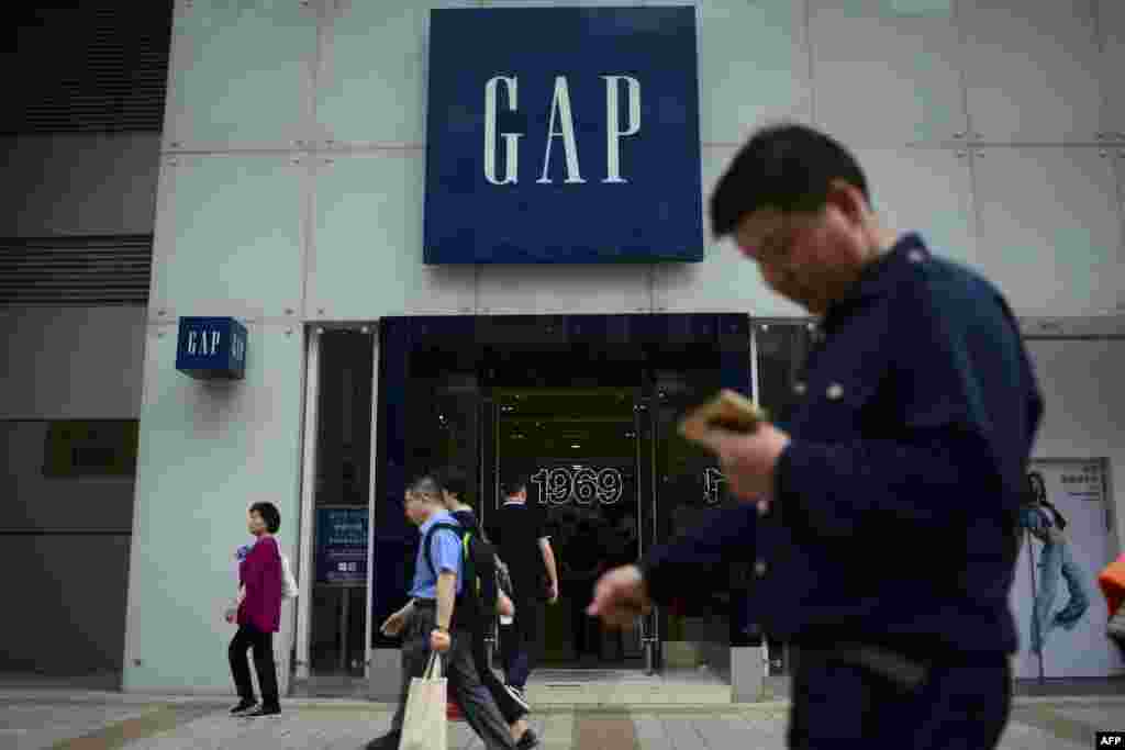 2018年5月15日,行人在北京的一条商业街上走过Gap服装店。 官方5月15日公布的数据显示,中国工业产出在4月份超过预期,但零售额下滑。这个全球第二大经济体面临债务问题和对美贸易摩擦的压力。美国服装公司Gap(盖璞)5月14日由于印在其一款T恤衫上的中国地图没有包括台湾而向中国道歉。创立于1969年的Gap是美国最大的美式休闲服饰公司之一,该公司在中国和台湾都设有专卖店。