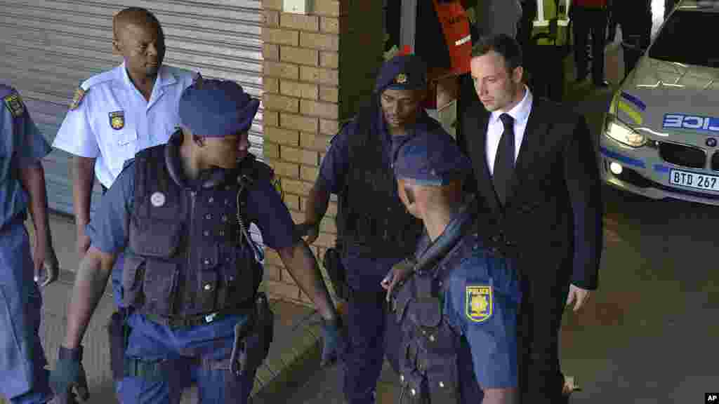 Oscar Pistorius est amené à un véhicule de police en attendant d'être conduit en prison, à Pretoria, Afrique du Sud, le 21 octobre 2014.