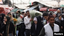 FILE - Iranian people walk at a flower market, ahead of Nowruz, the Persian new year, in Tehran, Iran, March 17, 2024. (Majid Asgaripour/WANA via Reuters)