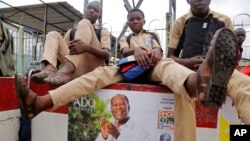 Des enfants assis sur des affiches de campagne du président sortant ivoirien, Alassane Ouattara, à Abidjan, Côte d'Ivoire, 21 octobre 2015. (AP Photo/Schalk van Zuydam)