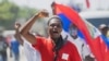 FILE - A man protesting the deportation of Haitian migrants by the United States marches toward the U.S. Embassy, in Port-au-Prince, Haiti, Sept. 26, 2021.