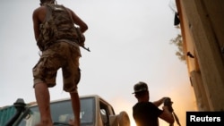 FILE - Fighters loyal to Libya's U.N.-backed government fire guns during clashes with forces loyal to Khalifa Haftar on the outskirts of Tripoli, Libya, May 25, 2019.