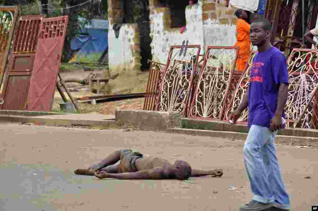 Locals suspect the unattended man in the street died from the deadly Ebola virus even though the government warns the public not to leave Ebola victims in the streets, in Monrovia, Liberia, Aug. 5, 2014.