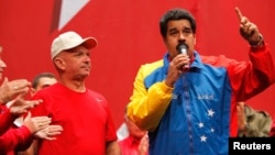 El presidente en disputa de Venezuela, Nicolás Maduro, (derecha) habla junto al general retirado Hugo Carvajal, en Caracas, el 27 de julio, de 2014. 