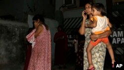 Local women who rushed outdoors following tremors speak on their cellphones, in Kolkata, India, April 13, 2016. A strong earthquake struck Myanmar on Wednesday night and was felt in parts of eastern India and Bangladesh.