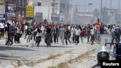 Para pendukung kelompok radikal Ansar al-Sharia bentrok dengan polisi Tunisia hari Minggu (19/5). 