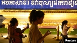 People walk using their mobiles phones in Phnom Penh, Cambodia, Feb. 18, 2021. The Cambodian government issued a subdecree Tuesday to establish a National Internet Gateway that would give it control over the flow of information on the internet.