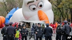 Petugas polisi berdiri di dekat tempat balon besar karakter Olaf dari "Frozen" yang sedang digelembungkan untuk parade Hari Thanksgiving di New York, Rabu, 22 November 2017.