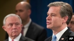Attorney General Jeff Sessions listens as FBI Director Christopher Wray speaks during a news conference about the arrest of Cesar Sayoc, 56, of Aventura, Fla., in the package bomb case, at the Department of Justice, Oct. 26, 2018, in Washington. 