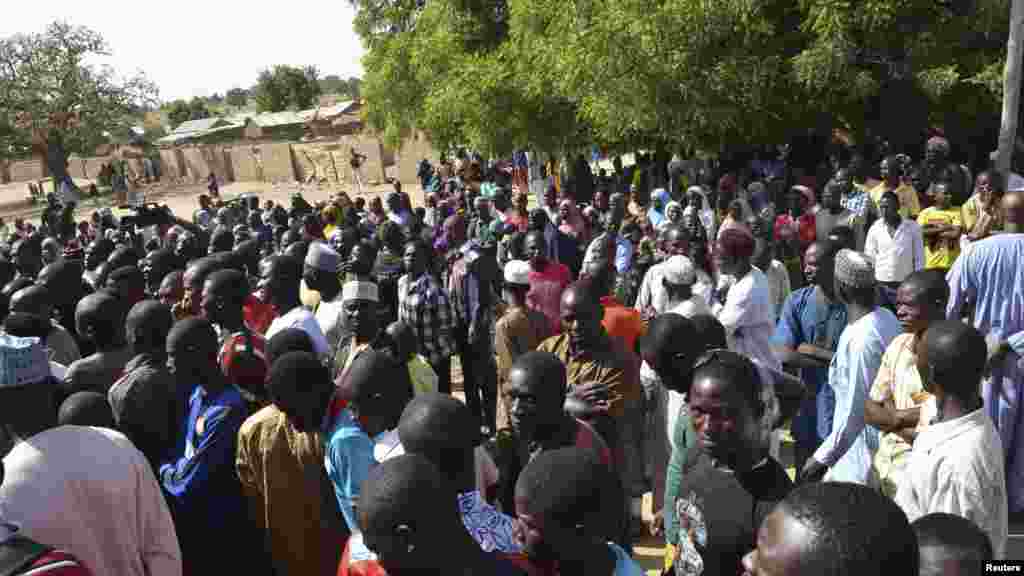 Wasu mutane kennan daga Gwoza, jihar Borno, da tashe-tashen hankula ya raba da gidajensu, suna taro a sansanin ‘yan gudun hijira a lokacin da gwamnan jihar Borno Kashim Shettima (babu hotonshi) a garin Mararaba Madagali, jihar Adamawa. Fabrairu 18, 2014.