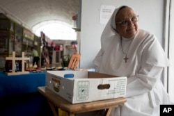 Sister Carmen Negrón, 64, sells handmade rosaries and religious icons in the Plaza del Mercado in San Juan, Puerto Rico, April 17, 2019. Negrón says she's noticed a drop in sales because of what seems to be fewer people in the area.