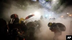 Federal officers launch tear gas at a group of demonstrators during a Black Lives Matter protest at the Mark O. Hatfield United States Courthouse in Portland, Oregon, July 26, 2020. 