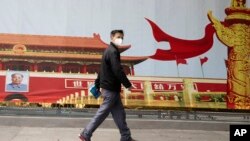 湖北武漢一名居民走過街頭一幅北京天安門的招貼畫。