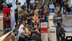 People lineup to get on the Air France flight to Paris at OR Tambo's airport in Johannesburg, South Africa', Nov. 26, 2021. A slew of nations moved to stop air travel from southern Africa on Friday in reaction to news of a new, potentially more transmissi