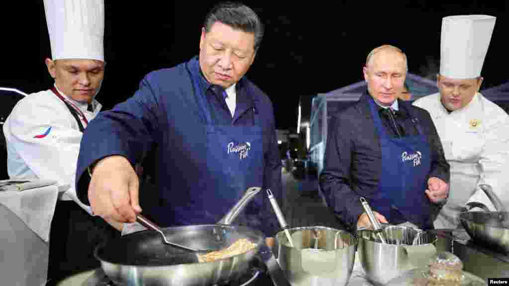 俄罗斯总统弗拉基米尔·普京和中国国家主席习近平2018年9月11日在俄罗斯符拉迪沃斯托克的东方经济论坛期间参观远东街展览,习近平摊煎饼——俄罗斯煎饼。在俄罗斯因为干预美国选举问题而同美国关系紧张之际,在中国与美国由于贸易争端而关系紧张之际,在俄罗斯符拉迪沃斯托克(又称海参崴)举行了东方经济论坛,俄中领导人在论坛期间举行了今年第三次会晤,加强两国合作关系。
