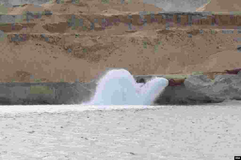 Giant waterspouts flow water from the old part of the canal to the new, raising the water level. Picture taken June 13, 2015). (Heather Murdock/VOA)